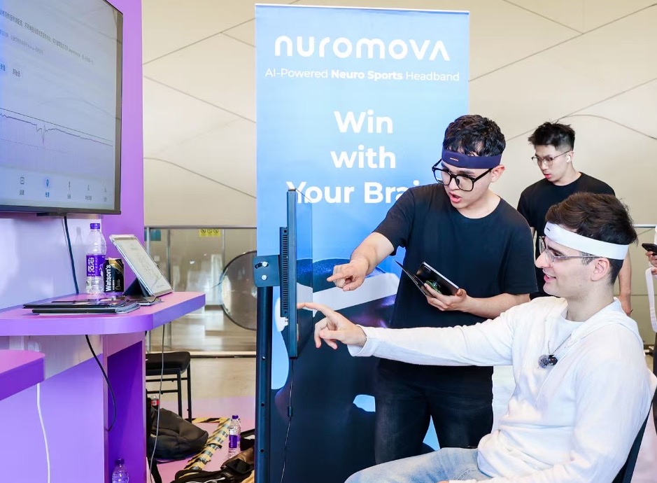 Visitor wearing a Nuromova headband during a guided cognitive assessment at an exhibition